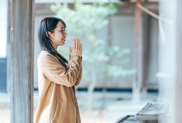 手を合わせて祈る女性